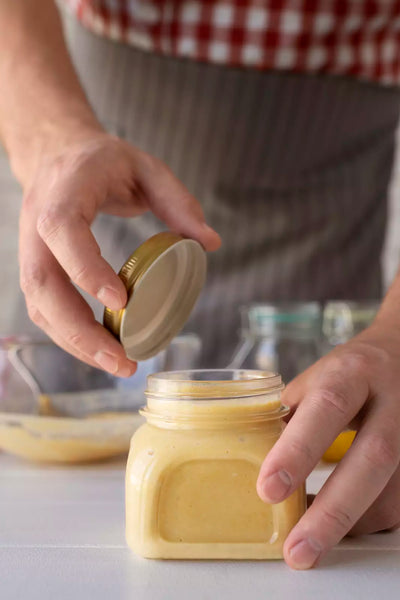 Close up shot of a guy storing healthy cream cheese spread in a jar.