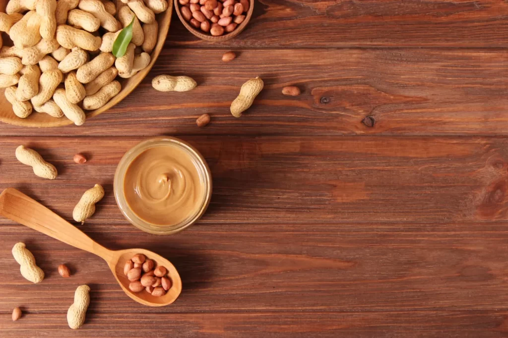 Peanut butter in bowl and peanuts in a spoon- high protein peanut butter blog