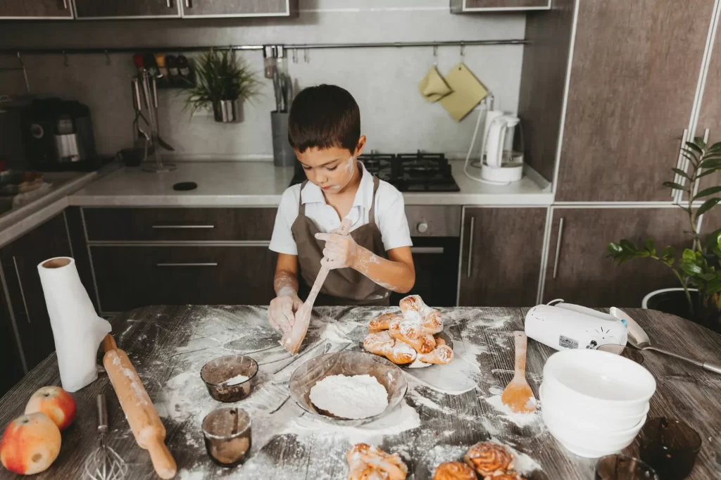 Little boy in kitchen making cream cheese recipes